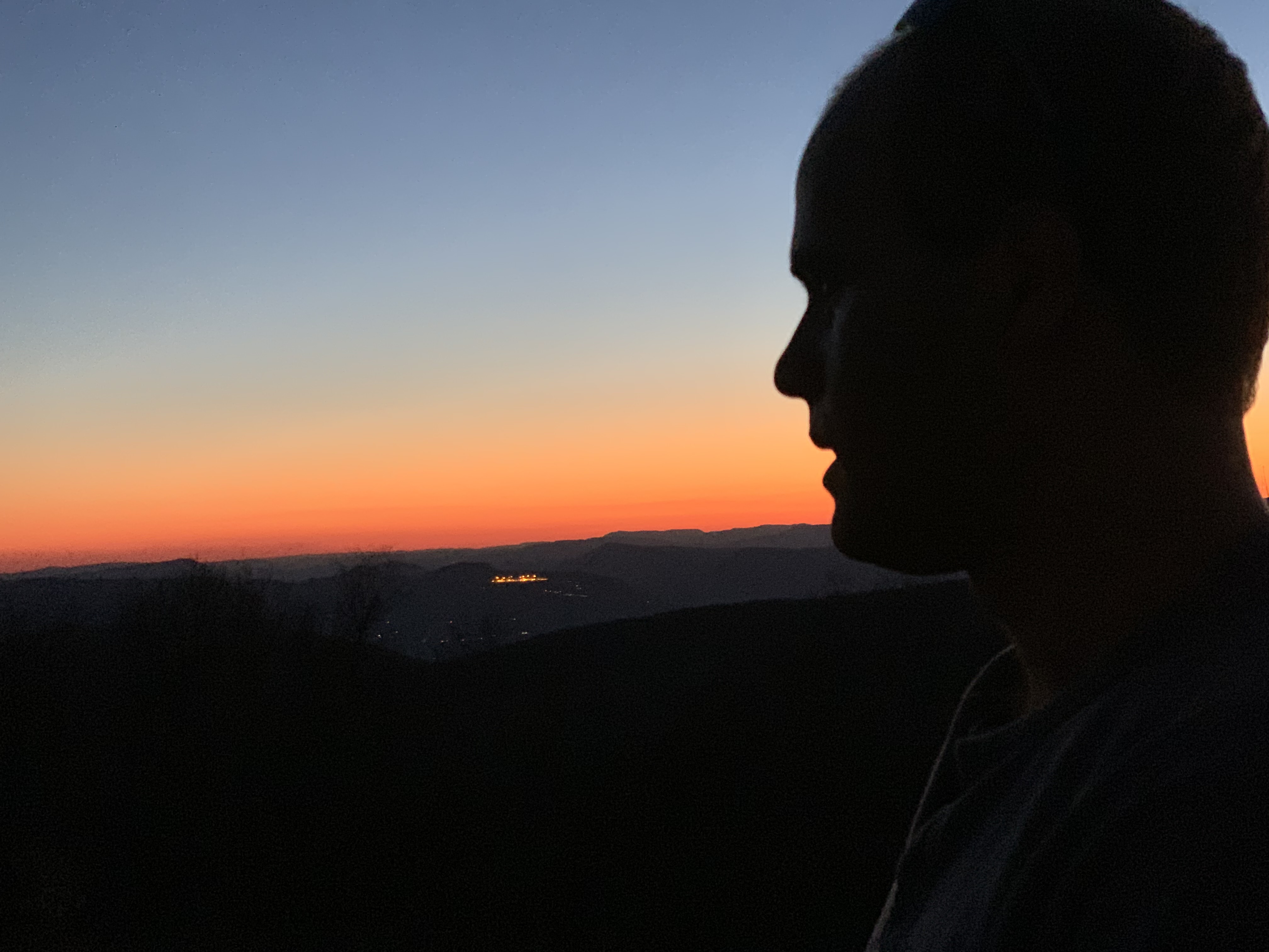 Silhouette of a man's head enjoying a sunset.